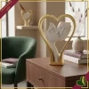 Scultura coppia di visi con cuore in marmorina bianco e oro, altezza 24 cm