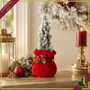 Composizione natalizia su pouf in velluto rosso con alberello innevato e bacche, altezza 23 cm