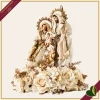 Natività in resina e tessuto avorio e oro su composizione floreale, altezza 60 cm