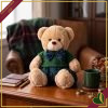Orsacchiotto in peluche beige con completo verde e dettagli tartan blu, altezza 20 cm